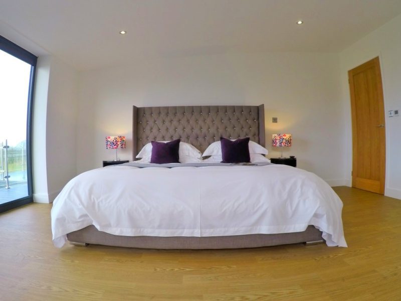 large double bed from a low aspect picture with the bedside lights turned on